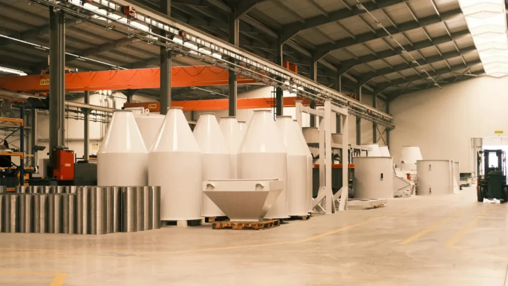 Interior pabrik industri berat dengan mesin besar dan bahan material produksi di lantai produksi